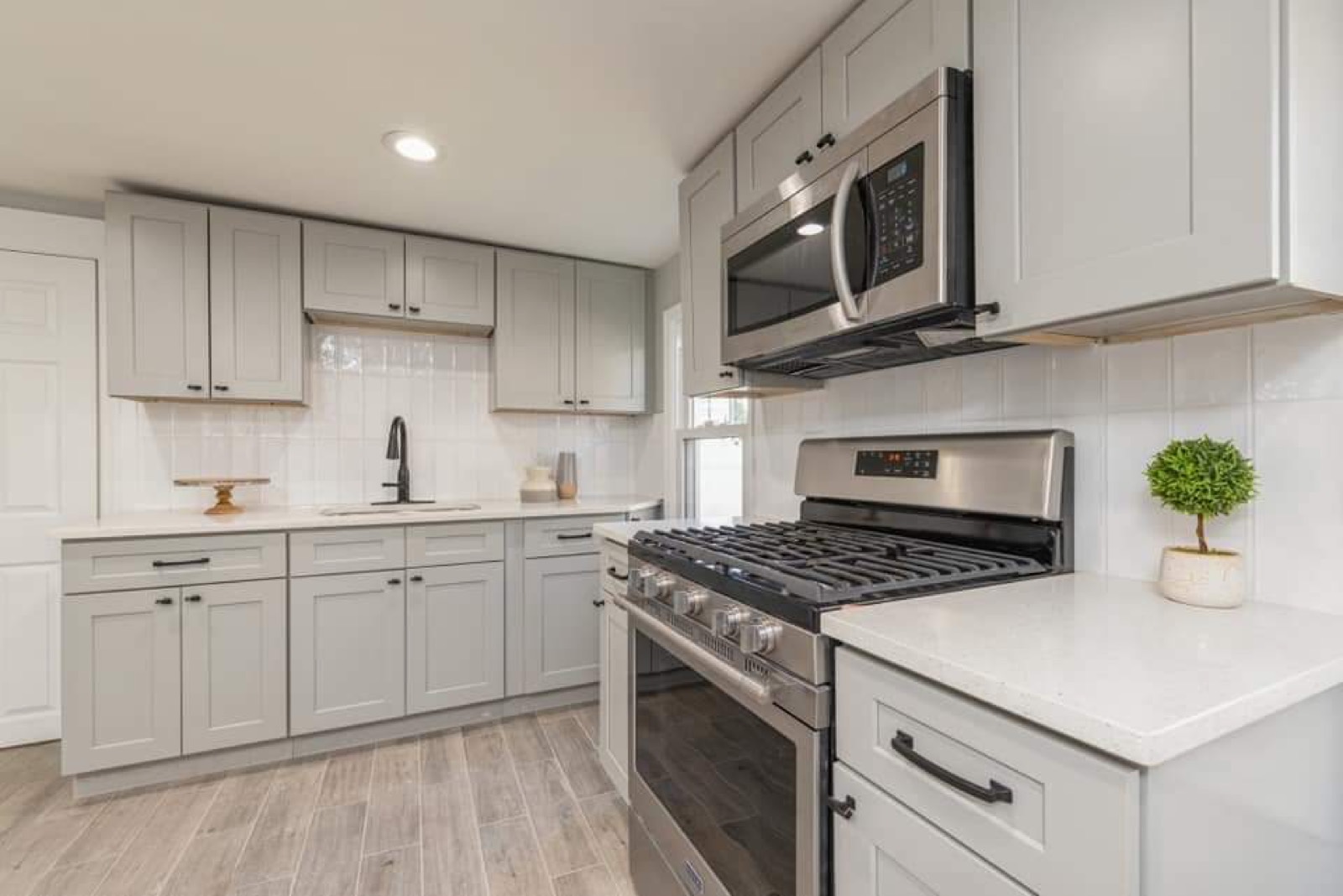 Grey shaker kitchen with quartz countertops and stainless steel appliances
