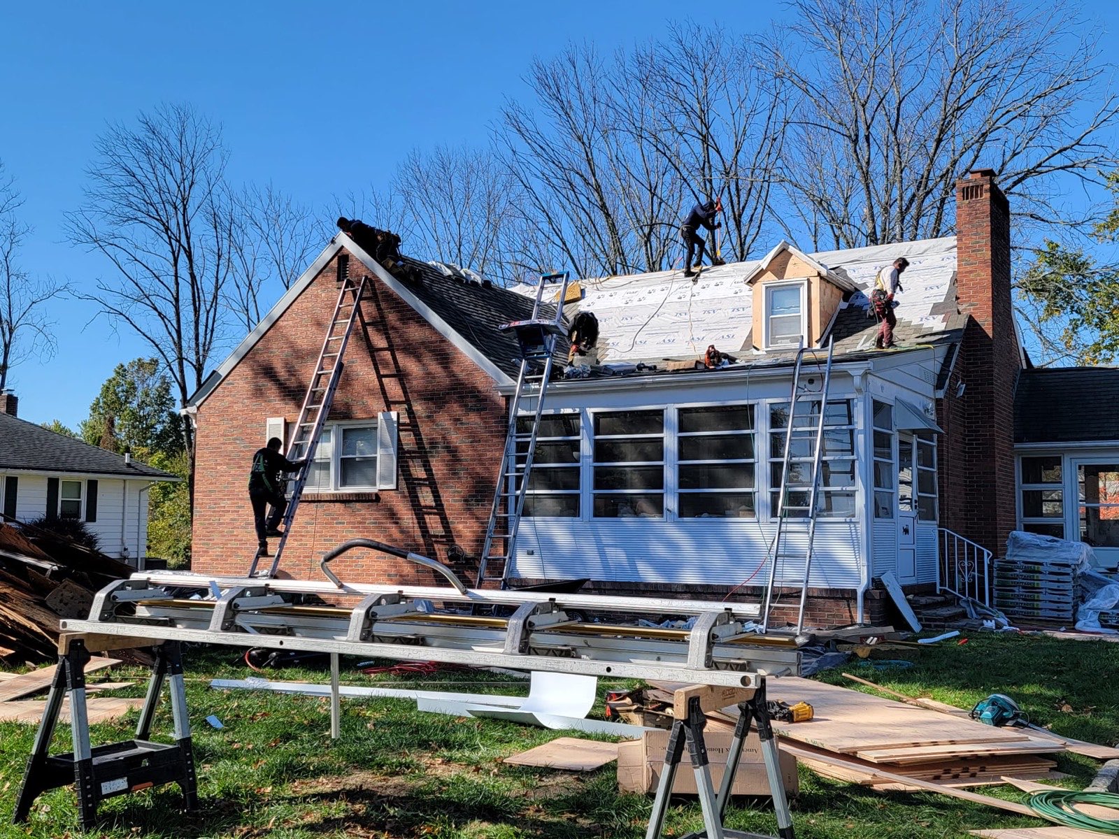 Crew replacing the roof on a brick home